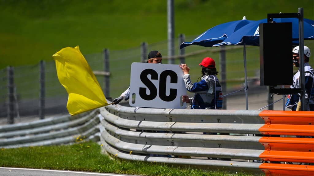 Marshals wave a yellow flag and display the safety car board, Mark Sutton, Motorsport Images