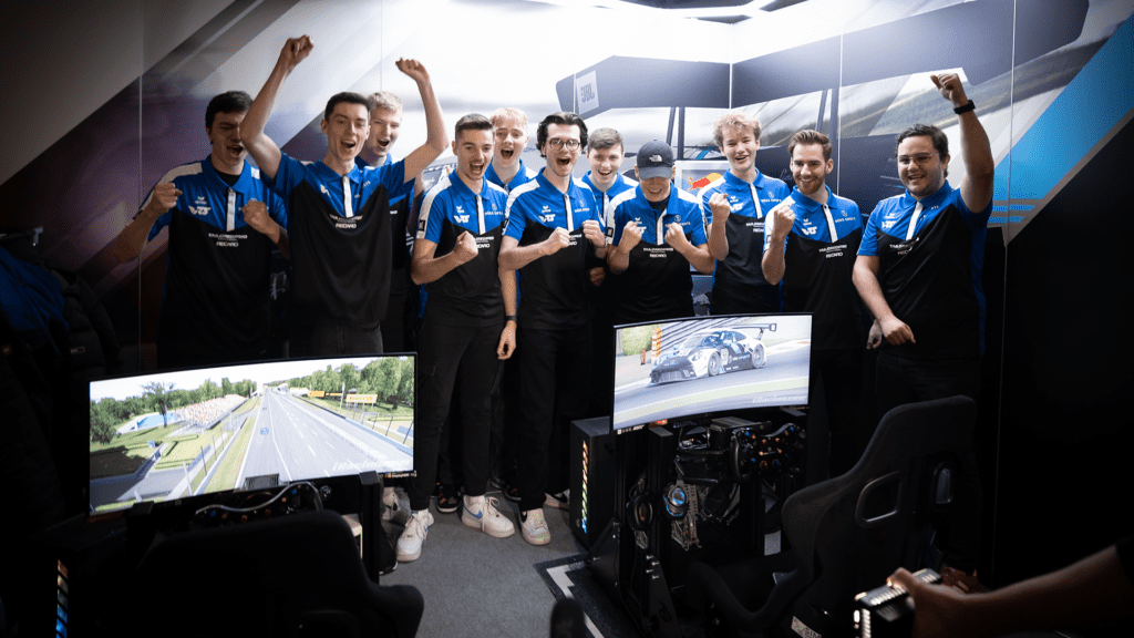 The Dörr Esports team give a cheer while standing in front of two sim rigs